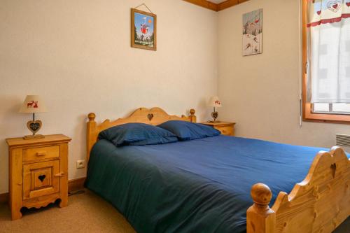 une chambre avec un lit avec des draps bleus et une fenêtre dans l'établissement Le Névé, à Saint-Gervais-les-Bains