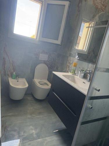 a bathroom with a toilet and a sink and a window at Casa di Nonni 