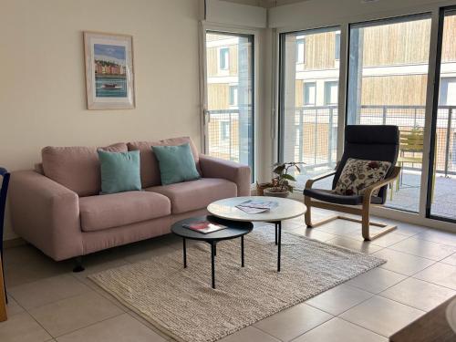 a living room with a couch and a chair at Côté Parc - appt entier neuf et cosy, parking & au pied du métro à Lyon in Vénissieux