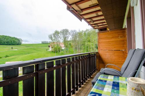 a balcony with chairs and a view of a field at Heizmannshof in Hofstetten