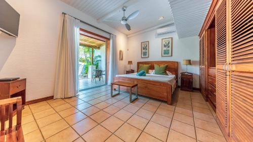 a bedroom with a bed and a sliding glass door at Shanti Ghar Guest House in Tamarin