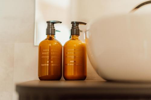 two bottles of orange liquid sitting on a shelf at Nowoczesne Domki na Drzewie - Kołobrzeg - Sauna - PolanaGlamp in Nieżyn