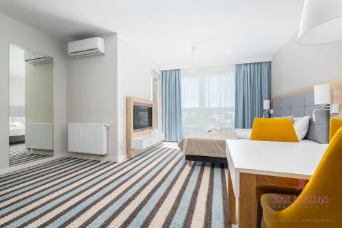 a hotel room with a bed and a tv at Your Holidays Bel Mare 407D in Międzyzdroje