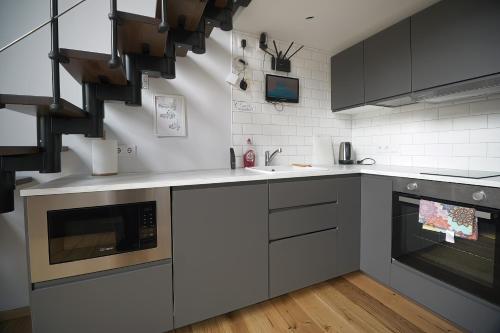 a kitchen with gray cabinets and a sink at KgB - 32, Stylish City Apartment - 10 mins walk to Old Town in Vilnius