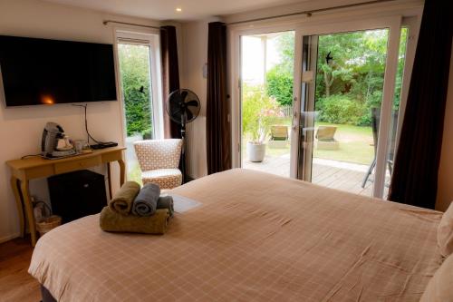 a bedroom with a large bed and a sliding glass door at De Zilte Zeehoeve in Ellemeet