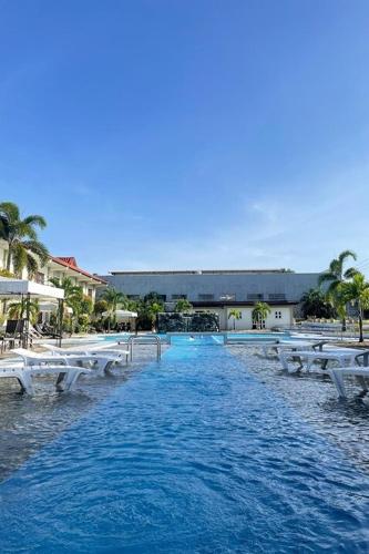 a swimming pool with white chairs in the water at Angeles Palace Hotel in Angeles