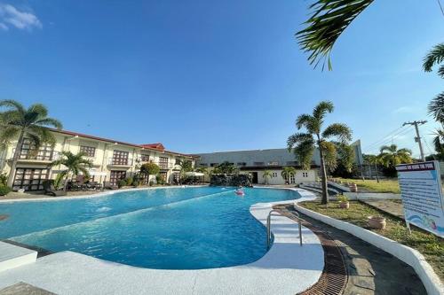 a large swimming pool in a resort with palm trees at Angeles Palace Hotel in Angeles