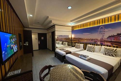 a hotel room with two beds and a flat screen tv at Angeles Palace Hotel in Angeles