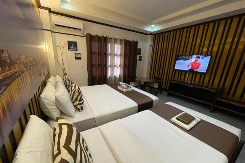 a hotel room with two beds and a flat screen tv at Angeles Palace Hotel in Angeles