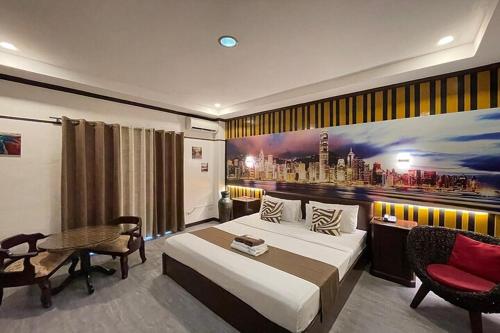 a bedroom with a large bed with a painting on the wall at Angeles Palace Hotel in Angeles