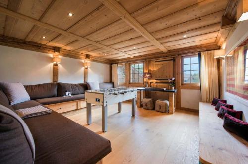 a living room with a couch and a table at Elegant Alpine Chalet with Spa in Lauenen