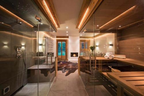 a bathroom with a tub and a glass shower at Elegant Alpine Chalet with Spa in Lauenen