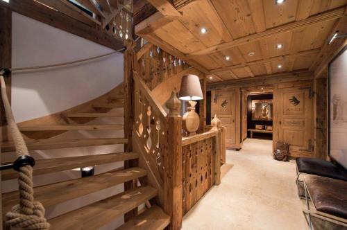 a wooden staircase in a room with wooden ceilings at Elegant Alpine Chalet with Spa in Lauenen
