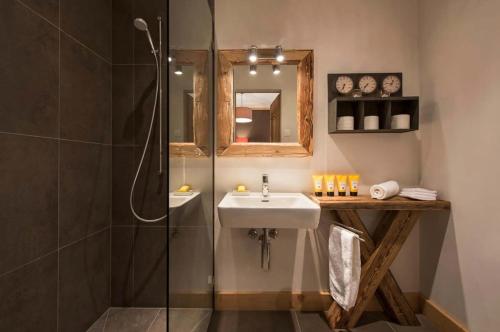 a bathroom with a sink and a shower at Elegant Alpine Chalet with Spa in Lauenen