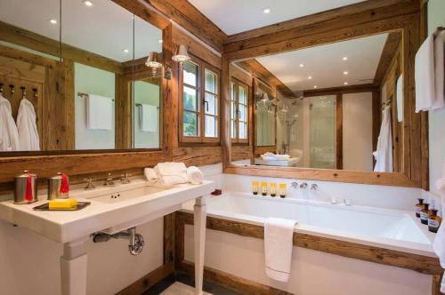a bathroom with a large tub and a large mirror at Elegant Alpine Chalet with Spa in Lauenen