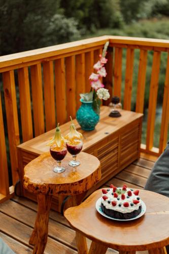 a table with a cake and two glasses of wine at Nowoczesne Domki na Drzewie - Kołobrzeg - Sauna - PolanaGlamp in Nieżyn