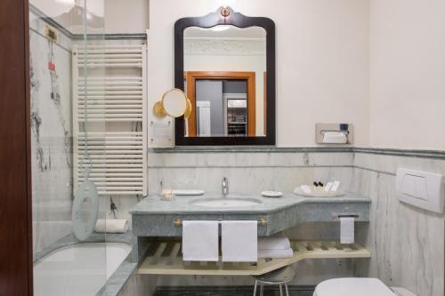 a bathroom with a sink and a mirror at Art Hotel Orologio in Bologna