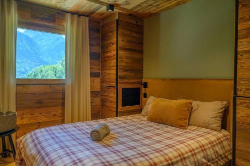 une chambre avec un lit avec une grande fenêtre dans l'établissement CHALET UTOPIA, à Saint-Gervais-les-Bains