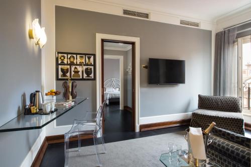 a living room with a couch and a tv on a wall at Art Hotel Orologio in Bologna
