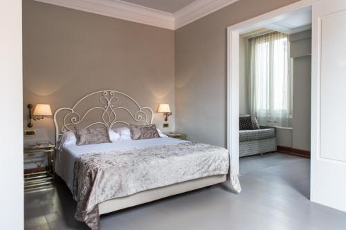 a bedroom with a large bed and a chair at Art Hotel Orologio in Bologna