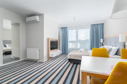 Una habitación de hotel con una cama y un televisor. en Your Holidays Bel Mare 402D, en Międzyzdroje