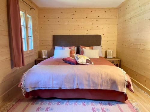 a bedroom with a large bed in a wooden room at Charming Chalet With Splendid Views Near Gstaad in Lauenen