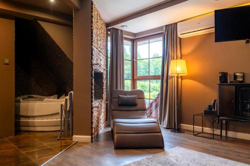 a living room with a large window and a couch at Caryńska Resort & SPA in Lutowiska