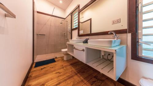 a bathroom with a sink and a toilet and a mirror at Shanti Ghar Guest House in Tamarin