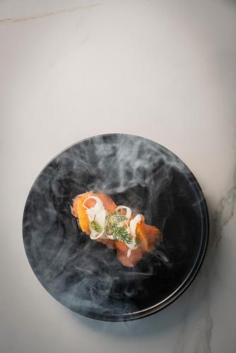 a black plate with food on a white table at Aqua Hotel in Rimini
