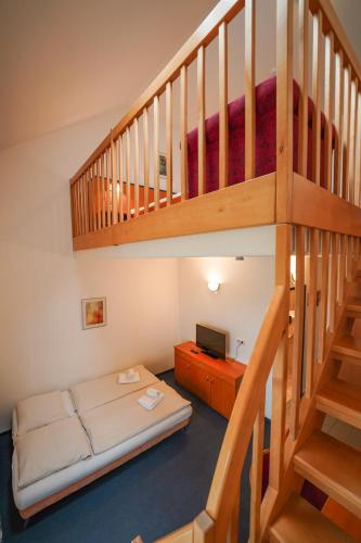 a room with a bunk bed and a staircase at Hotel Sonnenhof - Tante ALMA`s Sommerfrische in Sonnen