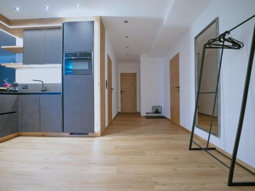 a kitchen with a large refrigerator and a wooden floor at BLACKSTYLE - Stylish Apartment with Balcony & Parking in Tyrol, presented by AlpenLuxus in Brixlegg