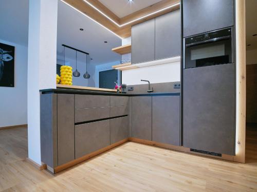 a kitchen with stainless steel appliances and wood floors at BLACKSTYLE - Stylish Apartment with Balcony & Parking in Tyrol, presented by AlpenLuxus in Brixlegg