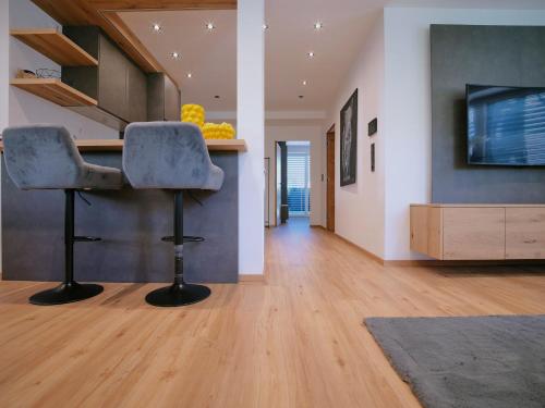 a living room with two chairs and a television at BLACKSTYLE - Stylish Apartment with Balcony & Parking in Tyrol, presented by AlpenLuxus in Brixlegg