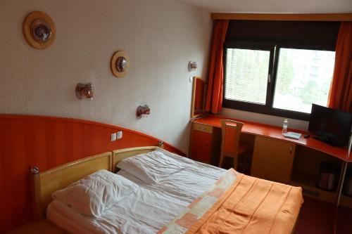 a bedroom with a bed and a desk with a computer at MC Hotel in Žalec