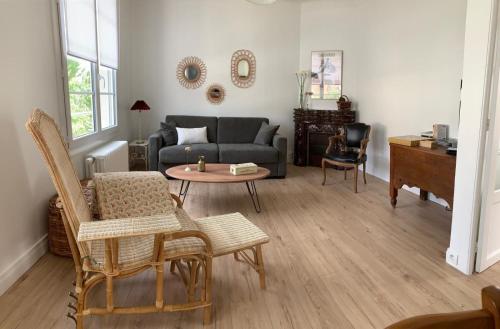 a living room with a couch and a table at La maison de Leonie 2 chb cour wifi in Châteauroux