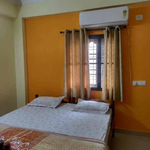 a bedroom with a bed and a window with curtains at Jamuna homestays in Secunderabad