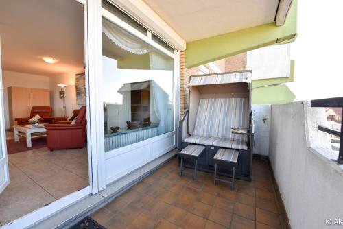 a balcony with two chairs and a window at Haus "Panorama" Appartement PAN063 in Duhnen