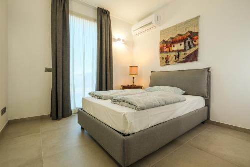 a bedroom with a bed and a large window at Agriturismo Casa Irma in Gargnano