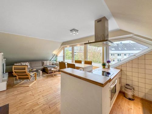 an open kitchen and living room with a large window at FeWo Rose 52 Travemünde in Travemünde