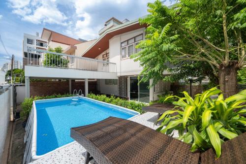 an exterior view of a house with a swimming pool at MIQ S22 Pool Villa PhromPhong Emsphere 5BR in Bangkok