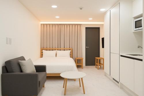 ソウルにあるJoin Stayのベッドとソファとテーブルのある寝室