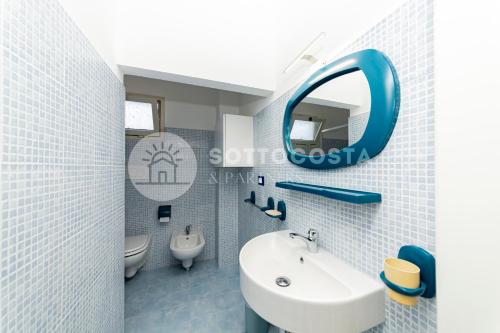 un bagno con un lavandino bianco e uno specchio di La Casina Di Mare a Porto Cesareo
