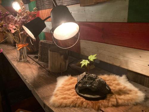 a table with a lamp and a faux fur rug at ふる郷荘Furusato Furano in Furano