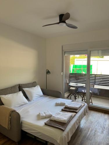a bedroom with a bed with a ceiling fan at Stylish Studio IVSOLE in Budva
