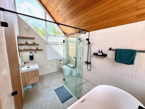 Das Bad ist mit einer Glasdusche und einer Badewanne ausgestattet. in der Unterkunft Luxury Retreat, Pool, Gym, Sauna, Spacious land & Garden in Ko Phangan