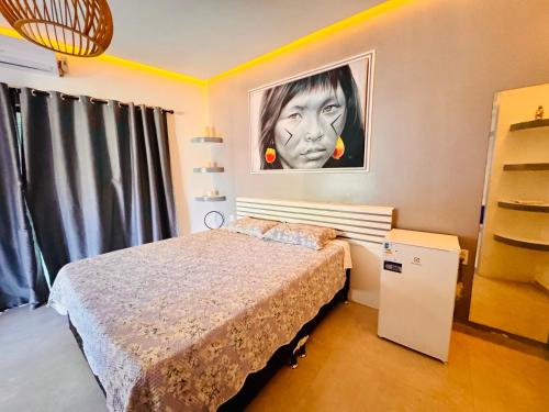 a bedroom with a bed and a picture of a woman at Enigma Casa Preá in Cruz