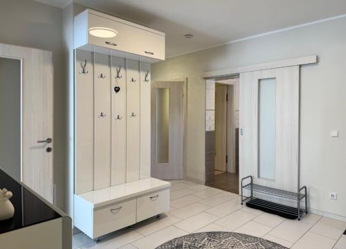 a dressing room with white cabinets and a mirror at FAAKER SEE HIDEAWAY - Apartment mit Garten in Faak am See