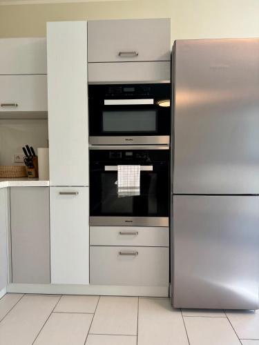 a stainless steel refrigerator and stove in a kitchen at FAAKER SEE HIDEAWAY - Apartment mit Garten in Faak am See