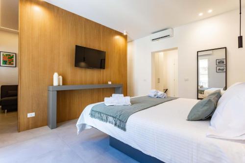 a bedroom with a bed and a tv on a wall at Capo D'Amuri in Palermo