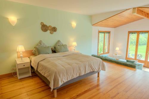 a bedroom with a large bed and a wooden floor at Chambres d'hôtes La Bastide in Puycalvel Lautrec